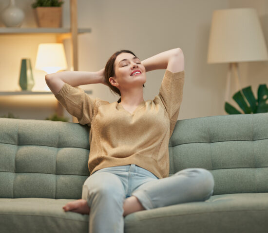 Une femme se repose sur un canapé dans son salon