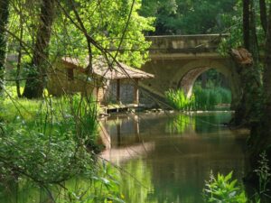 Ruisseau avec un pont en bois et un abri en pierre
